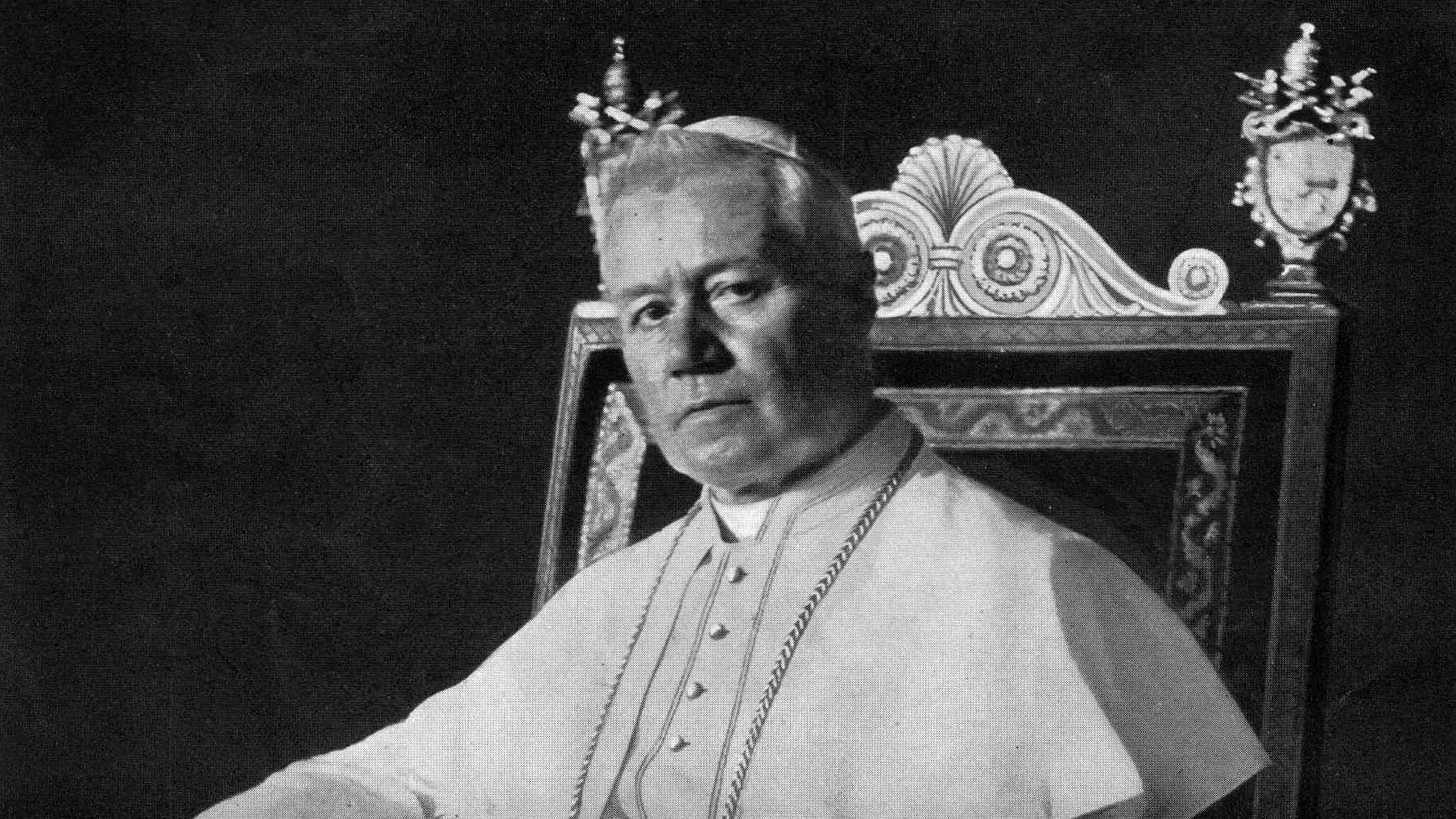 Portrait photographique du pape saint Pie X, assis sur le trône pontifical, en soutane blanche et mozette.